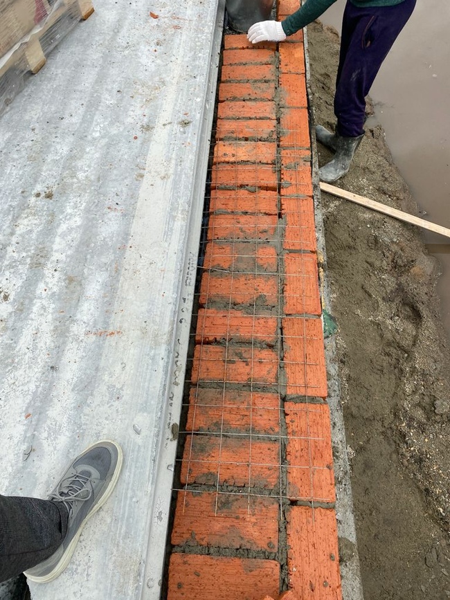 Выравниваем уровень под плиты полнотелым кирпичом.